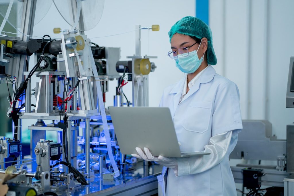 working on factory equipment with laptop